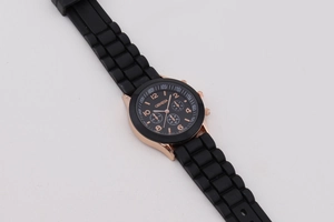 Detail of rose gold case with three sub-dials and textured black silicone strap