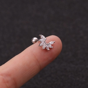 Macro shot of silver crescent zircon cartilage stud with ball screw back on finger