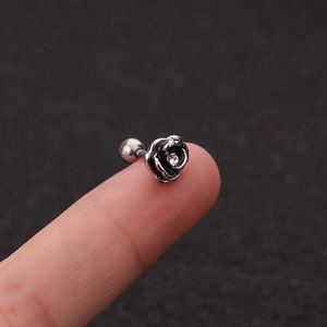 Macro shot of a black rose stud earring with a tiny zircon on a stainless steel post