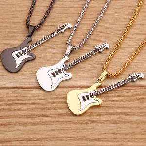 Detailed shot of guitar pendant necklaces in black, silver, and gold on a wood background