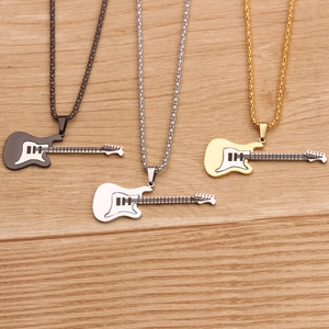 Detailed view of guitar pendant necklaces in black, silver, and gold on a wood background