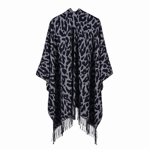 Detail of soft leopard print shawl with fringe trim and dark grey knit texture