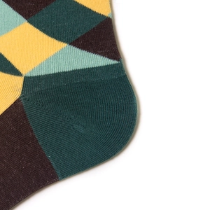 Gros plan de chaussettes en coton à losanges montrant la couture du talon et le motif