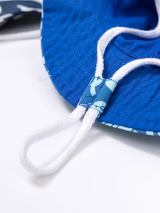 Dettaglio cappello alla pescatora in tela blu e bianca con cordino antivento regolabile