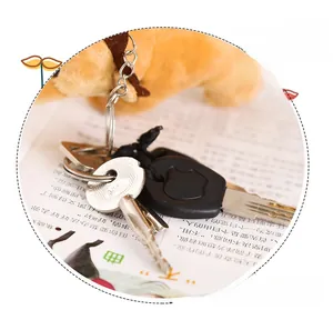 Detail view of a yellow plush lion keychain with a silver metal ring and decorative key