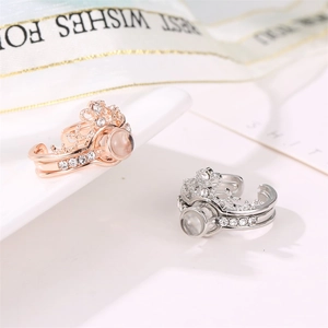 Macro shot of rose gold and silver crown rings with 100 languages projection stone