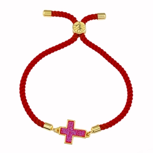 Dettaglio del bracciale in corda rossa intrecciata con ciondolo a croce dorata glitterata