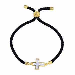 Dettaglio del bracciale regolabile in corda nera con croce dorata e perla con foglia