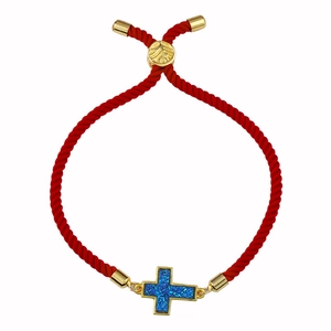 Dettaglio di bracciale rosso intrecciato con croce druzy blu dorata e chiusura a scorrimento