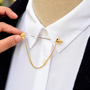 Gold-tone metal shirt collar pin with chain tassel being worn on white shirt collar