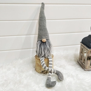 Detail of Christmas gnome with grey knit hat and striped legs on a birch wood base