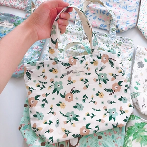Close-up of floral cotton tote bag with zipper and animal pattern woven label detail