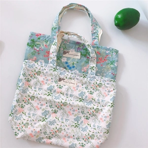 Flat lay view of floral cotton tote bags with a lime accent on a white background
