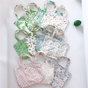 Flat lay of diverse floral and geometric patterns on cotton fabric zipper handbags