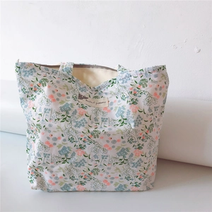 Detail of floral canvas tote bag showing zipper closure and Animal patterns label
