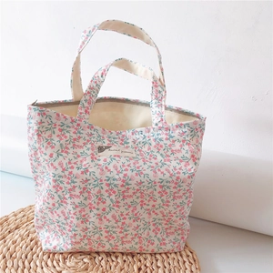 Detailed view of the floral cotton handbag with zipper closure and woven label