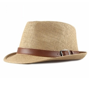 Close-up of woven fedora hat texture with brown leather band and silver buckle