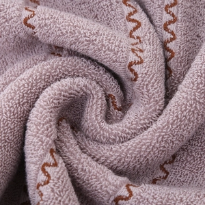 Thick cotton towel with brown wave pattern in pink, showing soft terry loops texture
