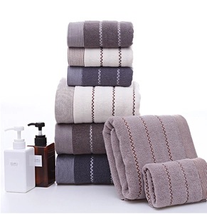 Close-up of thick cotton towels in purple and grey with ripple embroidery detail