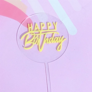 Dettaglio topper torta rotondo in acrilico con scritta Happy Birthday gialla su sfondo arcobaleno