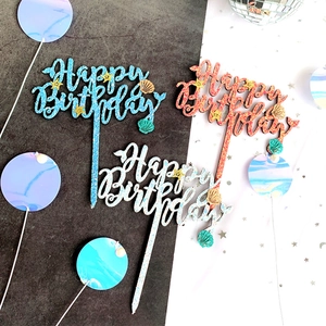 Macro shot of glitter Happy Birthday cake toppers in blue, pink and silver with pearls