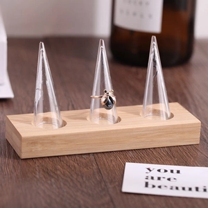 Bamboo and wood jewelry display stand with three clear acrylic ring cones and wooden base