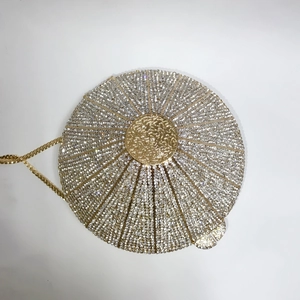 Macro shot of silver crystal rhinestones and golden center piece on round evening clutch bag