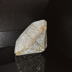 Close-up of diamond-shaped evening bag with white crystals and gold-tone metal frame