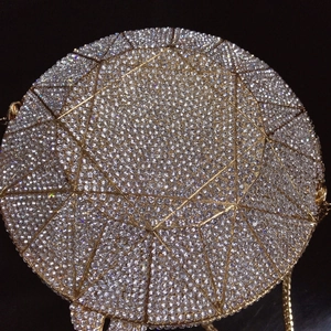 Macro shot of gold metal frame with high-brightness silver rhinestones for evening clutch bag