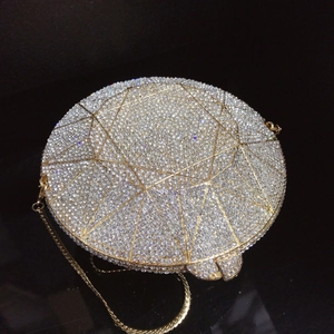 Detail view of round 3D diamond-shaped gold evening bag with sparkling silver crystals
