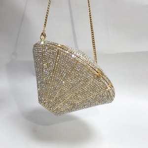 Detail of silver rhinestone evening clutch bag with gold chain strap and metal clasp