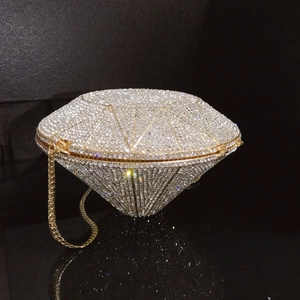 Macro detail of diamond-shaped evening clutch with silver crystals and gold chain