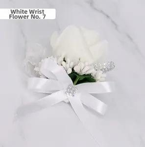 Detail of white rose wrist corsage with satin bow, rhinestones and faux berries
