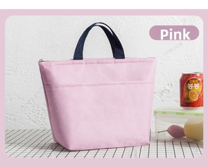 Detail of pink waterproof oxford lunch bag featuring navy blue handles and side pocket