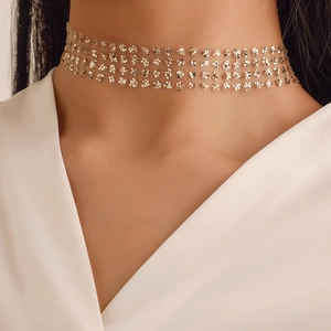 Gros plan du collier choker en mesh à paillettes dorées avec motifs floraux sur le cou