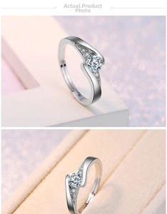 Detail of S-shaped silver ring with bright round solitaire and side accent stones