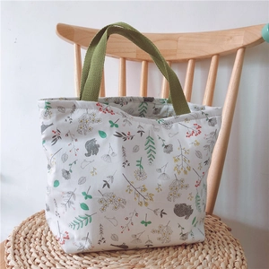 Detailansicht der grauen Blätter und Eichhörnchen-Muster auf der weißen Stofftasche