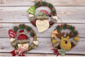 Three festive Christmas wreaths with Santa, Snowman, and Reindeer dolls on wooden background