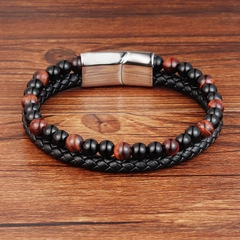 Detail view of double-layer woven black leather bracelet with red beads and silver magnetic clasp