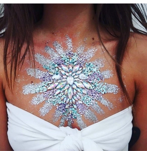 Close-up of radiant iridescent resin gem chest stickers with glitter for party makeup