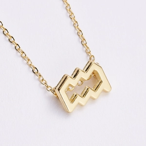 Detailed view of a gold-plated Aquarius zodiac pendant necklace with sparkling rhinestones