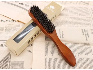 Detail of wooden beard brush with boar bristles and Cestomen packaging on vintage newspaper