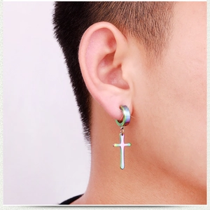 Detail of a colorful iridescent rainbow stainless steel cross earring on a male model