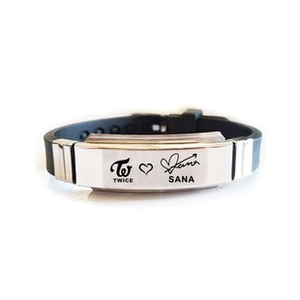 Detail of TWICE Sana signature engraved on silver plate with black rubber wristband