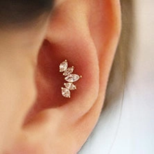 Nahaufnahme von Gold-Helix-Ohrstecker mit fünf Zirkonia im Marquise-Schliff am Ohr
