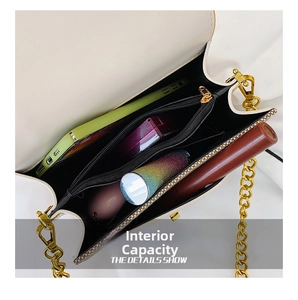Internal view of crossbody bag showing black compartments with gold chain and phone storage