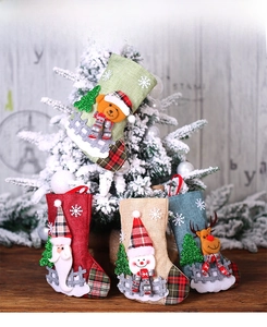 Detailed view of four rustic Christmas stockings with sequin trees and plaid cuffs