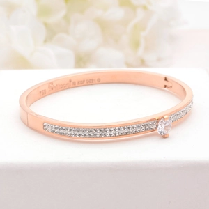 Detailed macro view of rose gold plated titanium steel bracelet with pavé setting and central crystal
