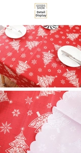 Detailed close-up of red Christmas tablecloth featuring white tree and snowflake patterns