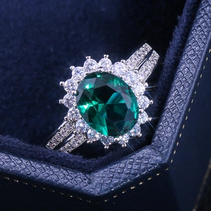 Macro view of green oval zircon engagement ring with halo and pave-set split shank